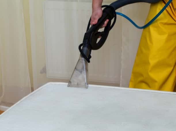 This is a photo of a man steam cleaning a dirty mattress works carried out by Herne Hill Carpet Cleaning.